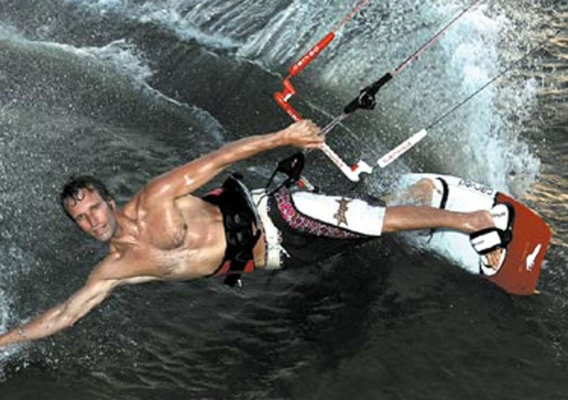 Bernd Hiss kitet an der Küste von Brasilien - Dunkles Wasser, ein Arm streift lässig durch das Wasser