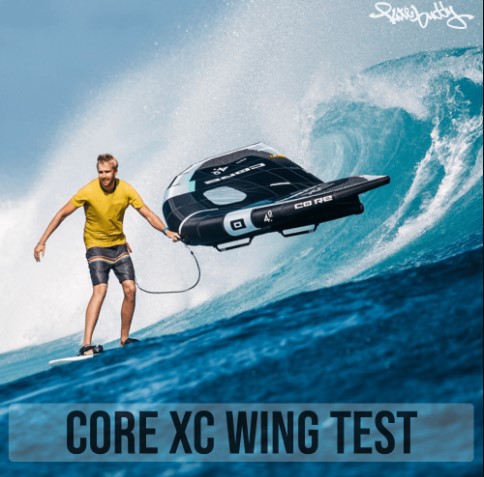 Wir sehen einen Wingsurfer der gerade eine Welle abreitet und der Core XC Wing ihm Hinterher fliegt. Hinter dem Wingsurfer bricht gerade eine Welle.